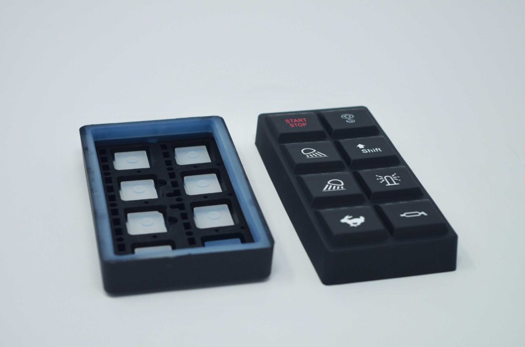 Standalone molded rubber; light blocks are molded into the part for backlighting and preventing light bleed.